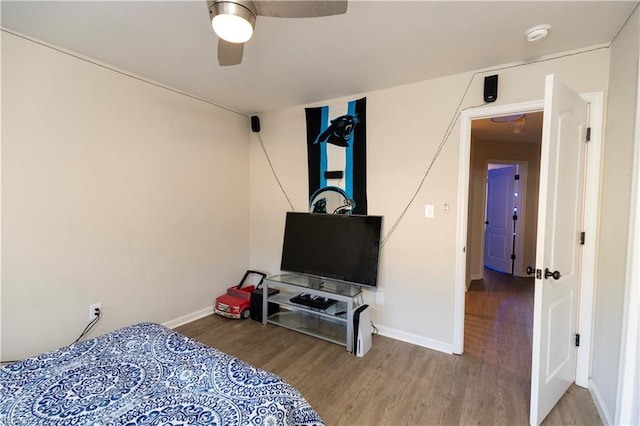 bedroom featuring a ceiling fan, baseboards, and wood finished floors