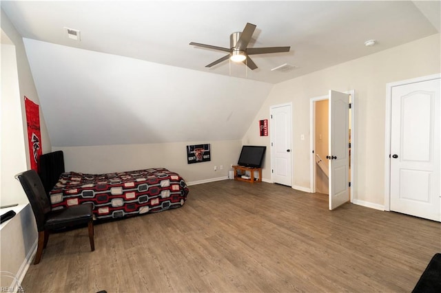 bedroom with vaulted ceiling, wood finished floors, visible vents, and baseboards