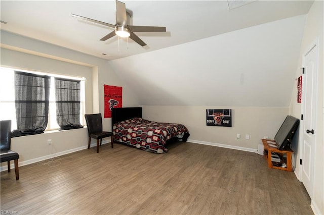 bedroom featuring lofted ceiling, wood finished floors, a ceiling fan, and baseboards