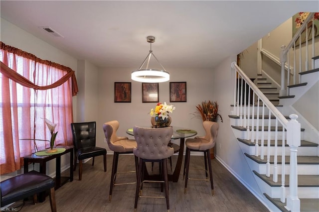 dining area featuring baseboards, stairs, visible vents, and wood finished floors