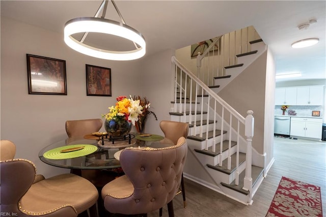 dining area with stairway and wood finished floors