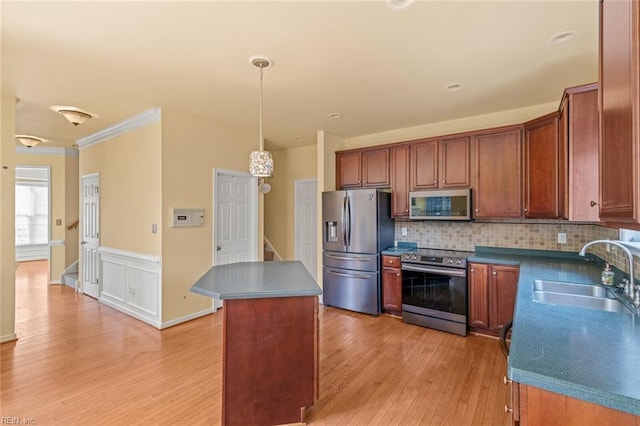 kitchen with a center island, stainless steel appliances, backsplash, light wood-style flooring, and a sink