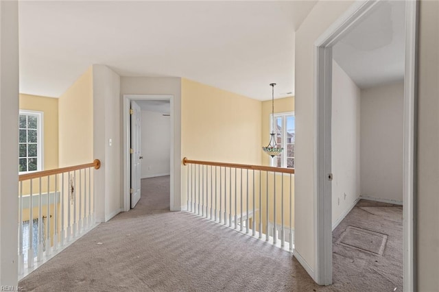 hallway with carpet floors, baseboards, and a wealth of natural light