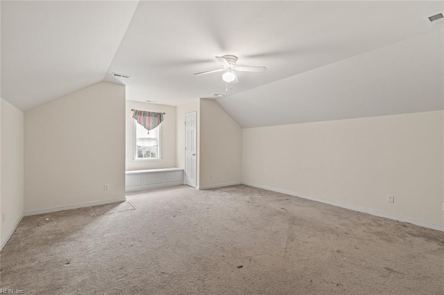 additional living space with vaulted ceiling, carpet flooring, visible vents, and a ceiling fan