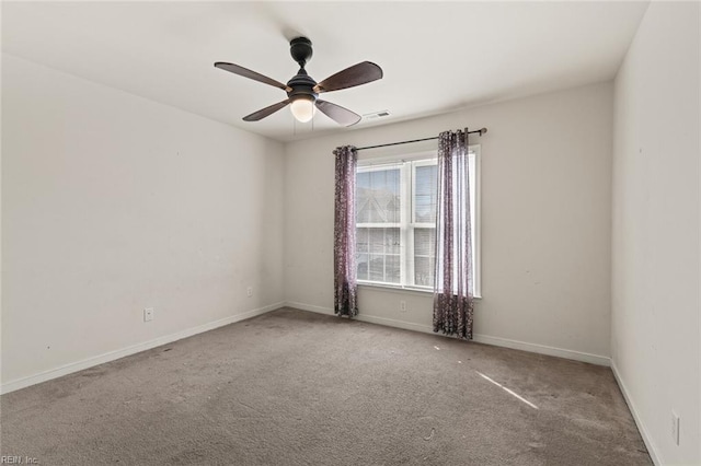 unfurnished room with carpet floors, a ceiling fan, visible vents, and baseboards