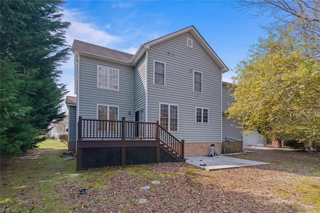 rear view of house featuring crawl space, a patio, and a wooden deck