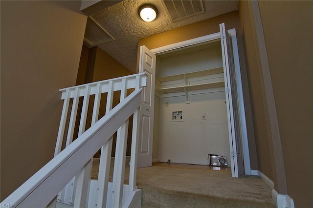 laundry room featuring a textured ceiling, laundry area, carpet floors, washer hookup, and visible vents