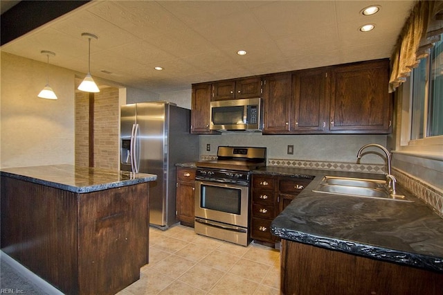 kitchen with decorative light fixtures, appliances with stainless steel finishes, light tile patterned flooring, a sink, and dark brown cabinetry