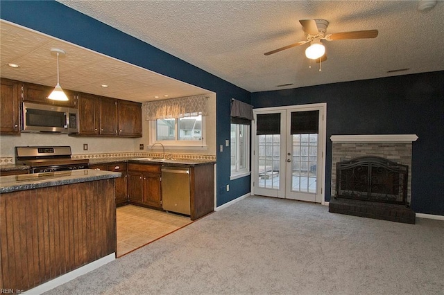 kitchen with appliances with stainless steel finishes, light colored carpet, and french doors