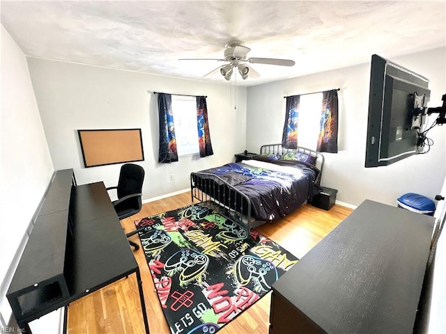 bedroom featuring ceiling fan, baseboards, and wood finished floors