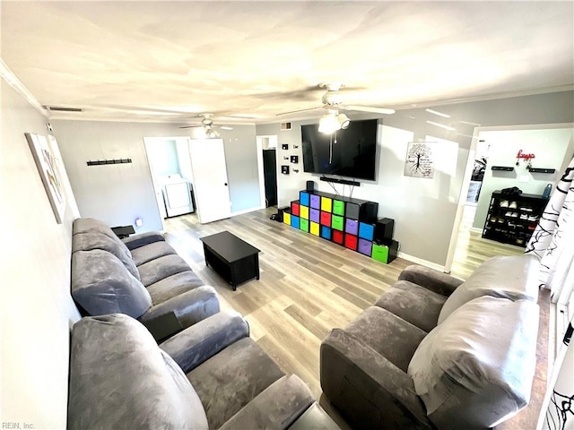 living room with light wood-type flooring, visible vents, washer / clothes dryer, and ornamental molding