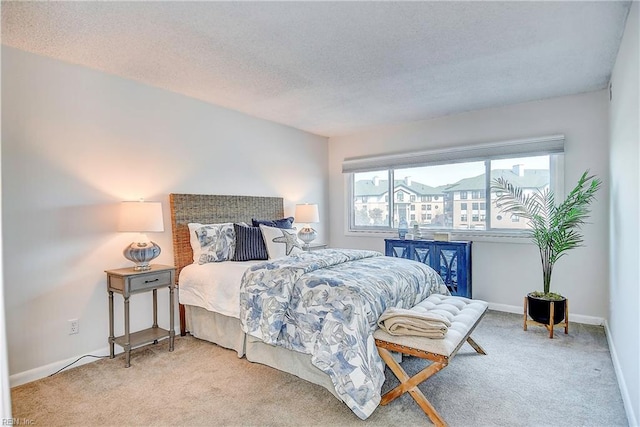 bedroom with carpet floors, baseboards, and a textured ceiling