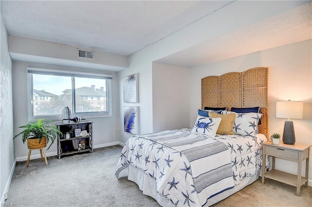 carpeted bedroom featuring visible vents, a textured ceiling, and baseboards