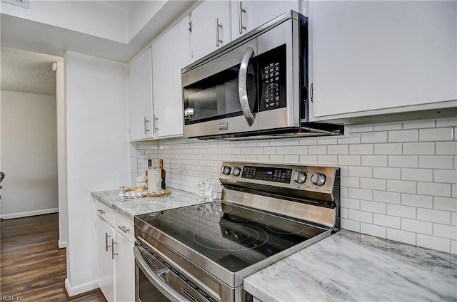 kitchen featuring white cabinets, tasteful backsplash, stainless steel appliances, and dark wood finished floors