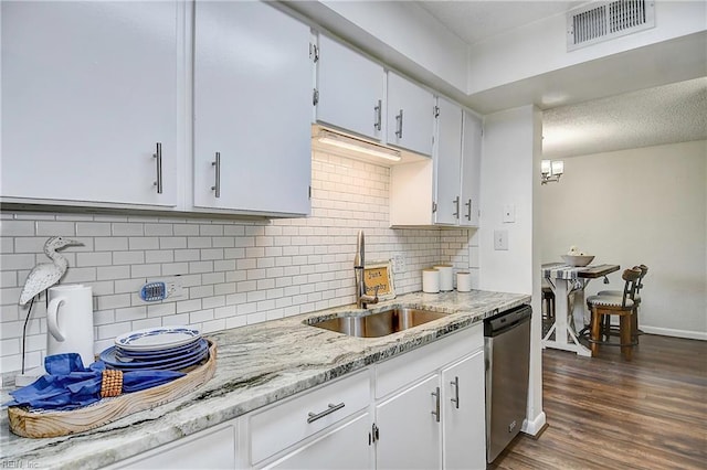 kitchen with a sink, visible vents, stainless steel dishwasher, backsplash, and dark wood-style floors