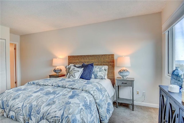 bedroom with carpet flooring, a textured ceiling, and baseboards