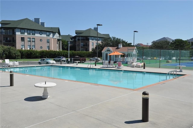 view of swimming pool featuring a patio area and fence