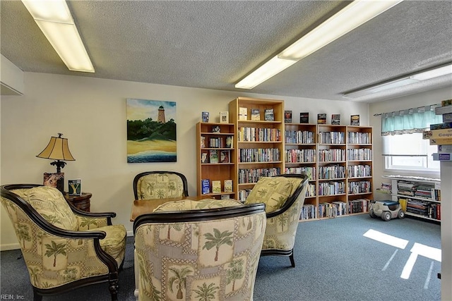 sitting room with a textured ceiling and carpet flooring