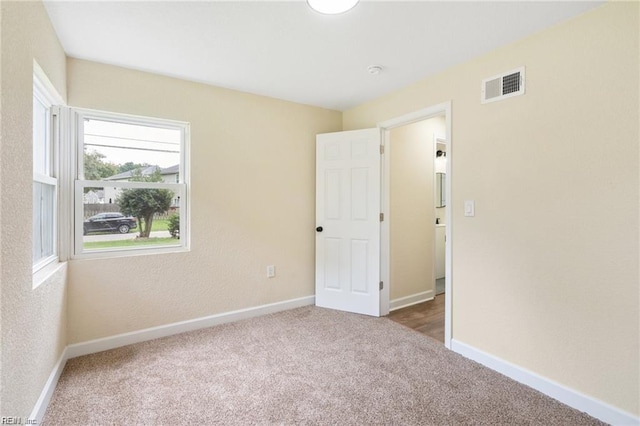 unfurnished bedroom featuring carpet, visible vents, and baseboards