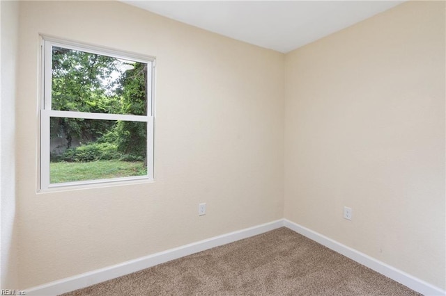 carpeted empty room with baseboards