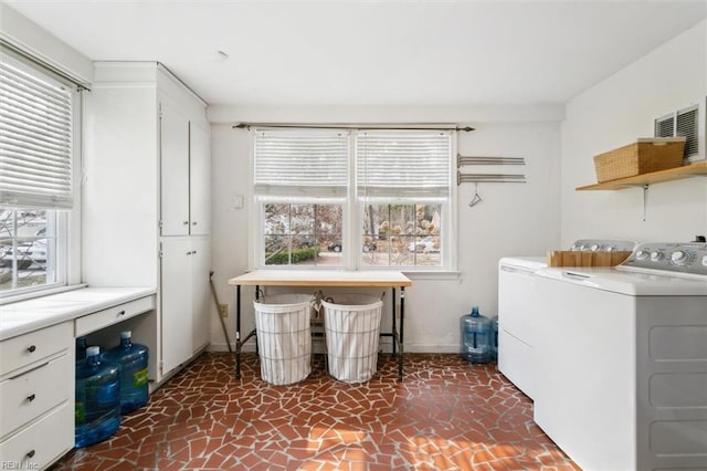 clothes washing area featuring laundry area, separate washer and dryer, and baseboards