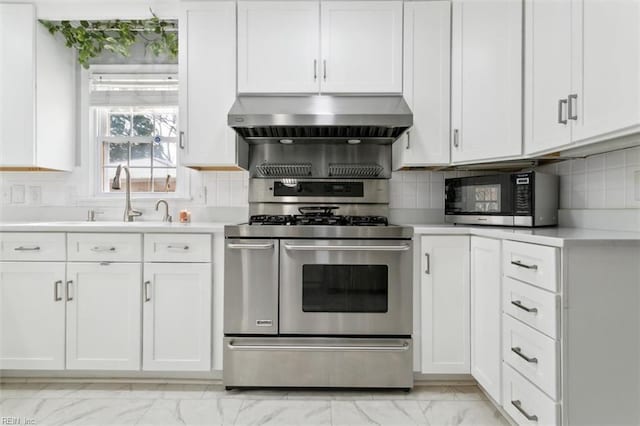 kitchen with range with two ovens, exhaust hood, white cabinetry, marble finish floor, and light countertops