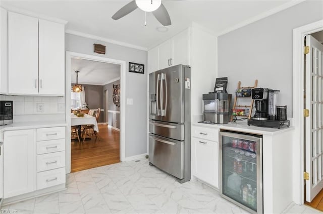 kitchen with stainless steel fridge, beverage cooler, marble finish floor, light countertops, and crown molding