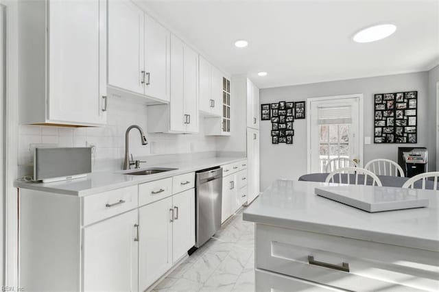 kitchen with a sink, marble finish floor, stainless steel dishwasher, light countertops, and decorative backsplash