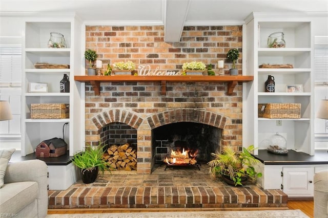 room details with a fireplace, ornamental molding, built in features, and wood finished floors