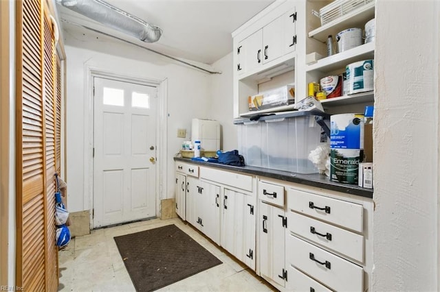 kitchen with dark countertops, white cabinets, and open shelves