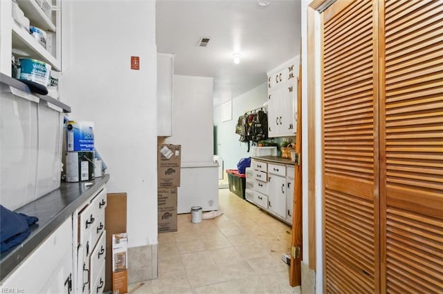 kitchen with dark countertops, visible vents, and white cabinets