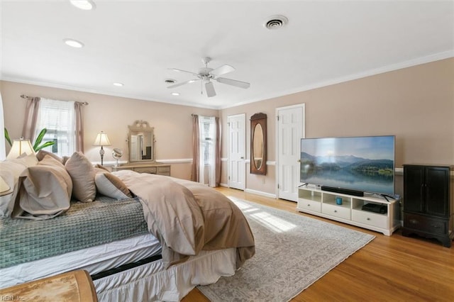 bedroom with baseboards, visible vents, crown molding, light wood-style floors, and recessed lighting