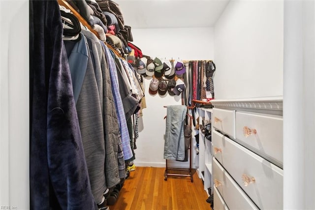 walk in closet with wood finished floors