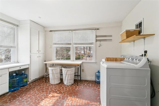 washroom featuring cabinet space, independent washer and dryer, and baseboards