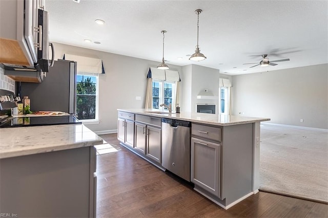 kitchen featuring ceiling fan, stainless steel appliances, a sink, hanging light fixtures, and gray cabinets