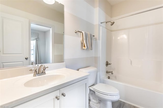 bathroom featuring wood finished floors, tub / shower combination, vanity, and toilet