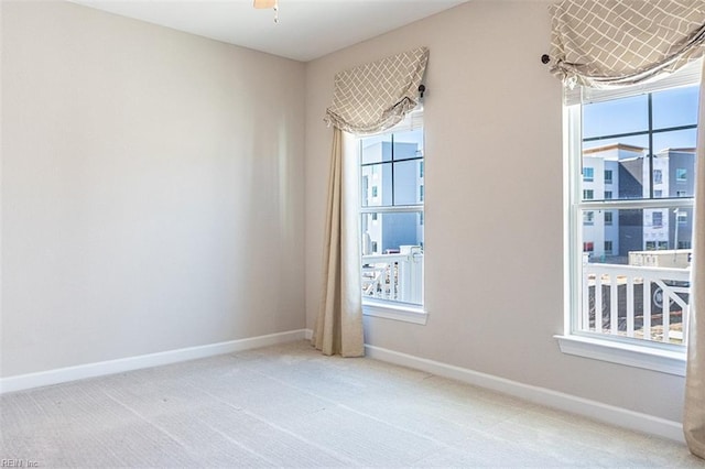 carpeted empty room featuring baseboards