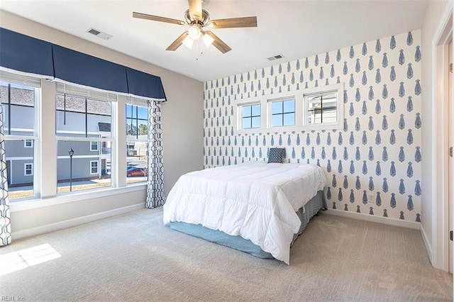 carpeted bedroom featuring baseboards, visible vents, and wallpapered walls