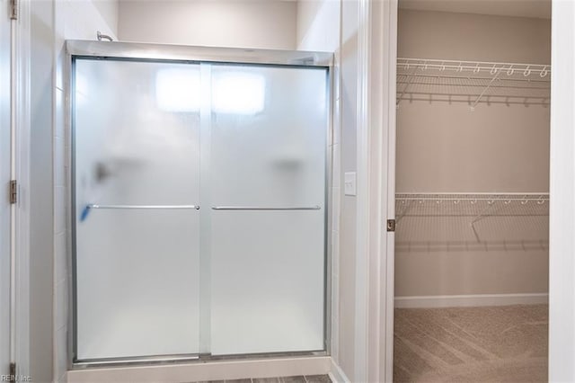 full bath featuring a stall shower and a walk in closet