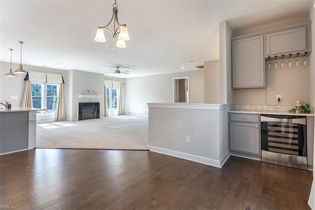 kitchen with beverage cooler, light countertops, gray cabinets, and decorative light fixtures