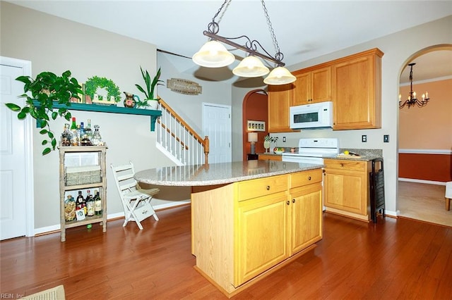 kitchen with white appliances, arched walkways, and dark wood finished floors