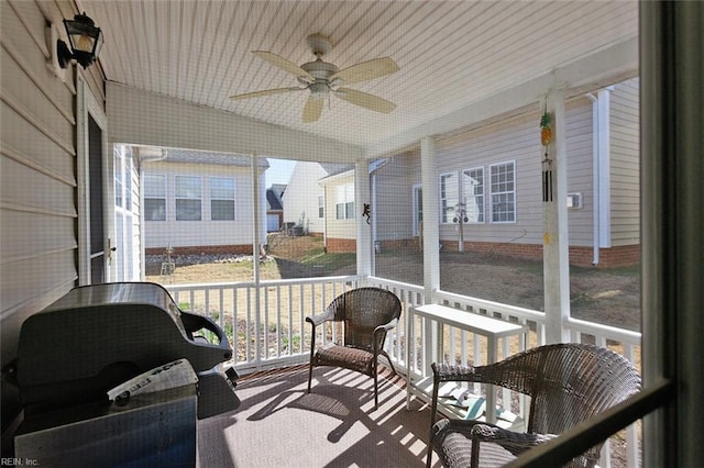 sunroom / solarium with lofted ceiling and a ceiling fan