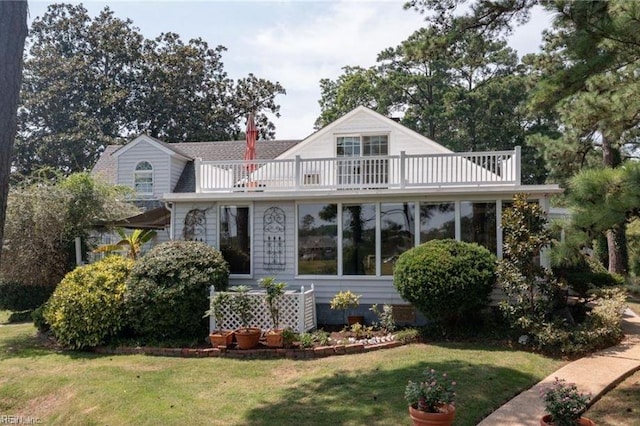 view of front of house with a balcony and a front lawn