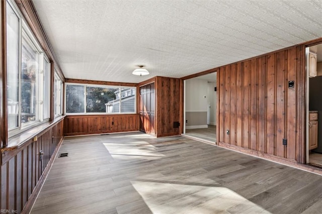 unfurnished sunroom featuring a healthy amount of sunlight and visible vents