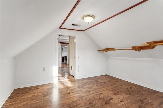 bonus room featuring lofted ceiling, baseboards, visible vents, and wood finished floors