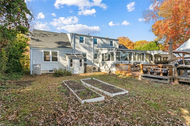 back of house with a deck, a yard, crawl space, and a vegetable garden