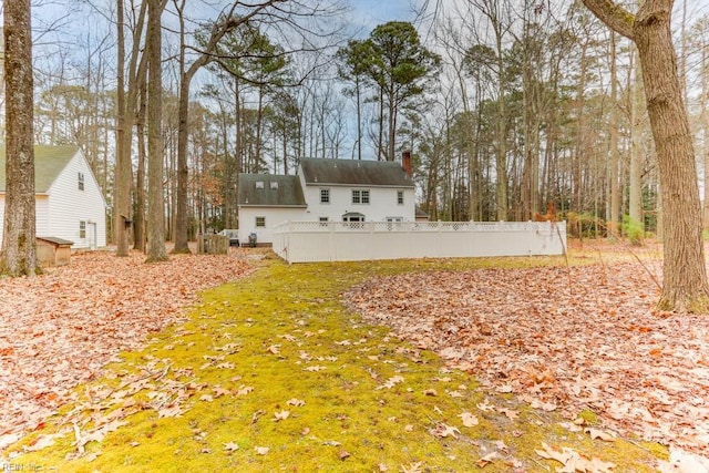 back of property with fence and a chimney