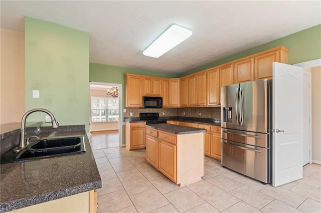 kitchen with tasteful backsplash, dark countertops, light brown cabinetry, black appliances, and a sink