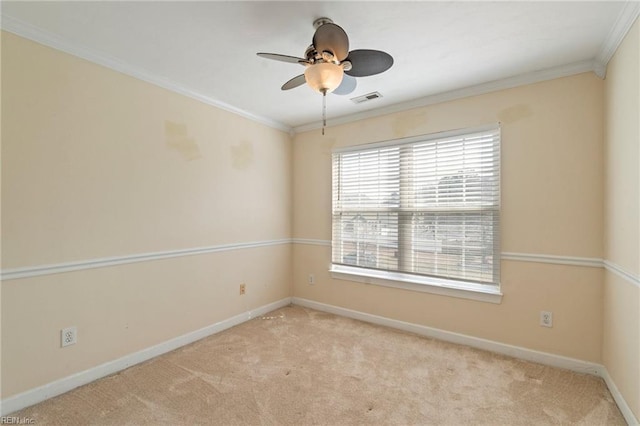 empty room featuring carpet floors, crown molding, visible vents, a ceiling fan, and baseboards