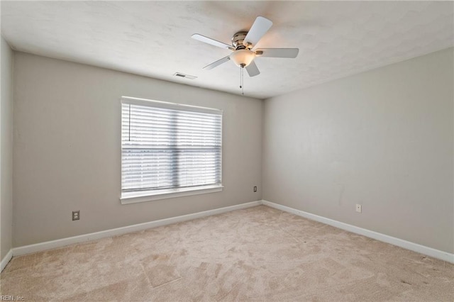 spare room featuring ceiling fan, carpet flooring, visible vents, and baseboards